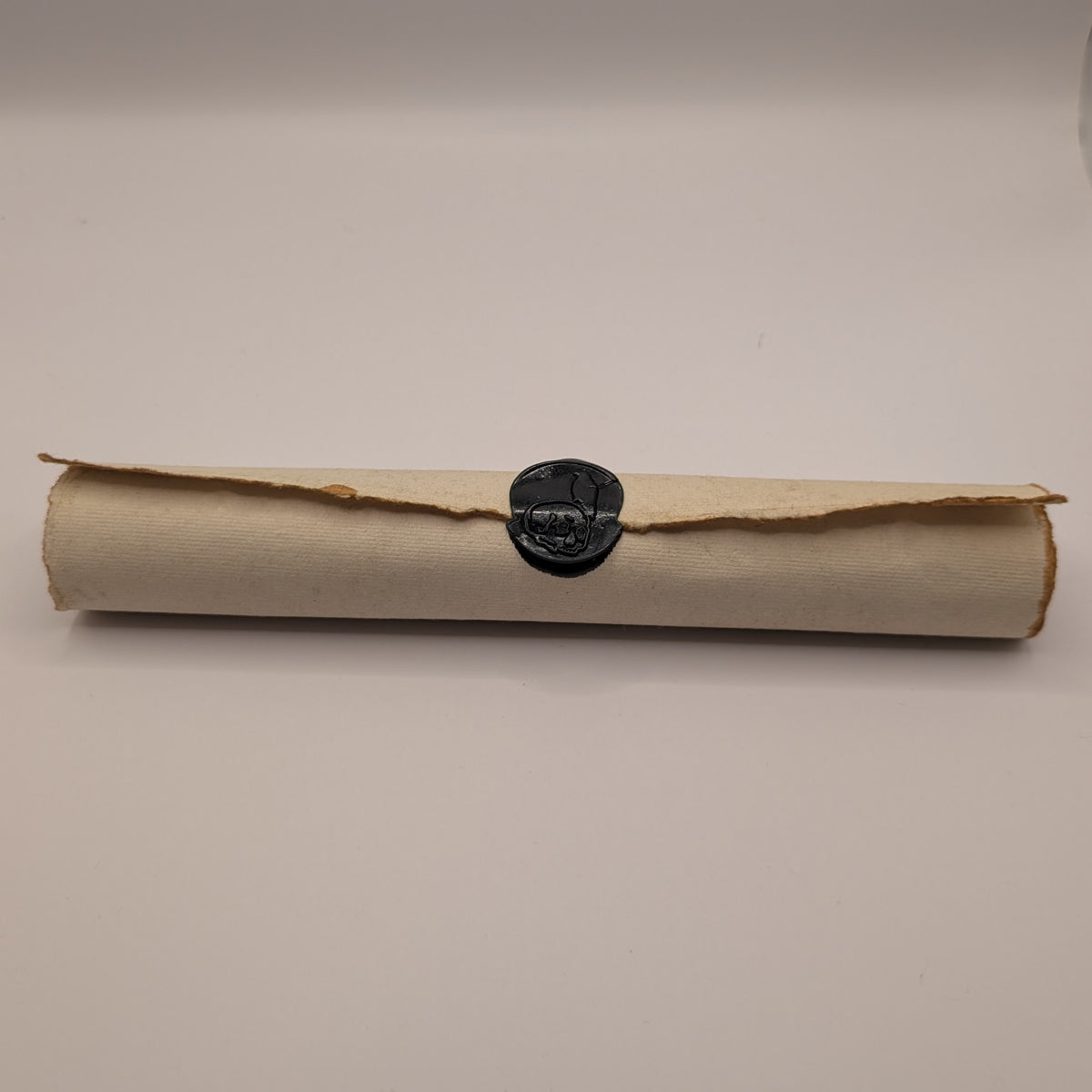 Doom Scroll: rolled deckle-edge curse scroll sealed with a black wax skull and raven seal